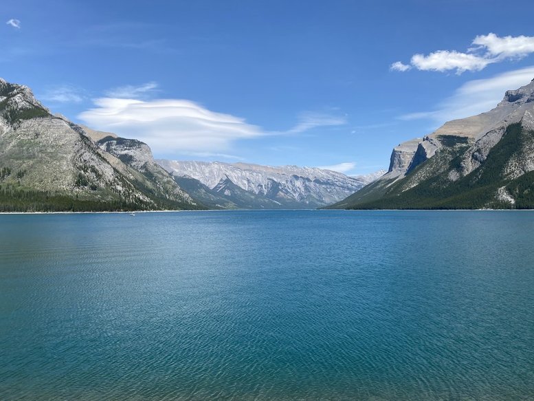 A vast, vibrant blue lake surrounded by a massive mountain range
