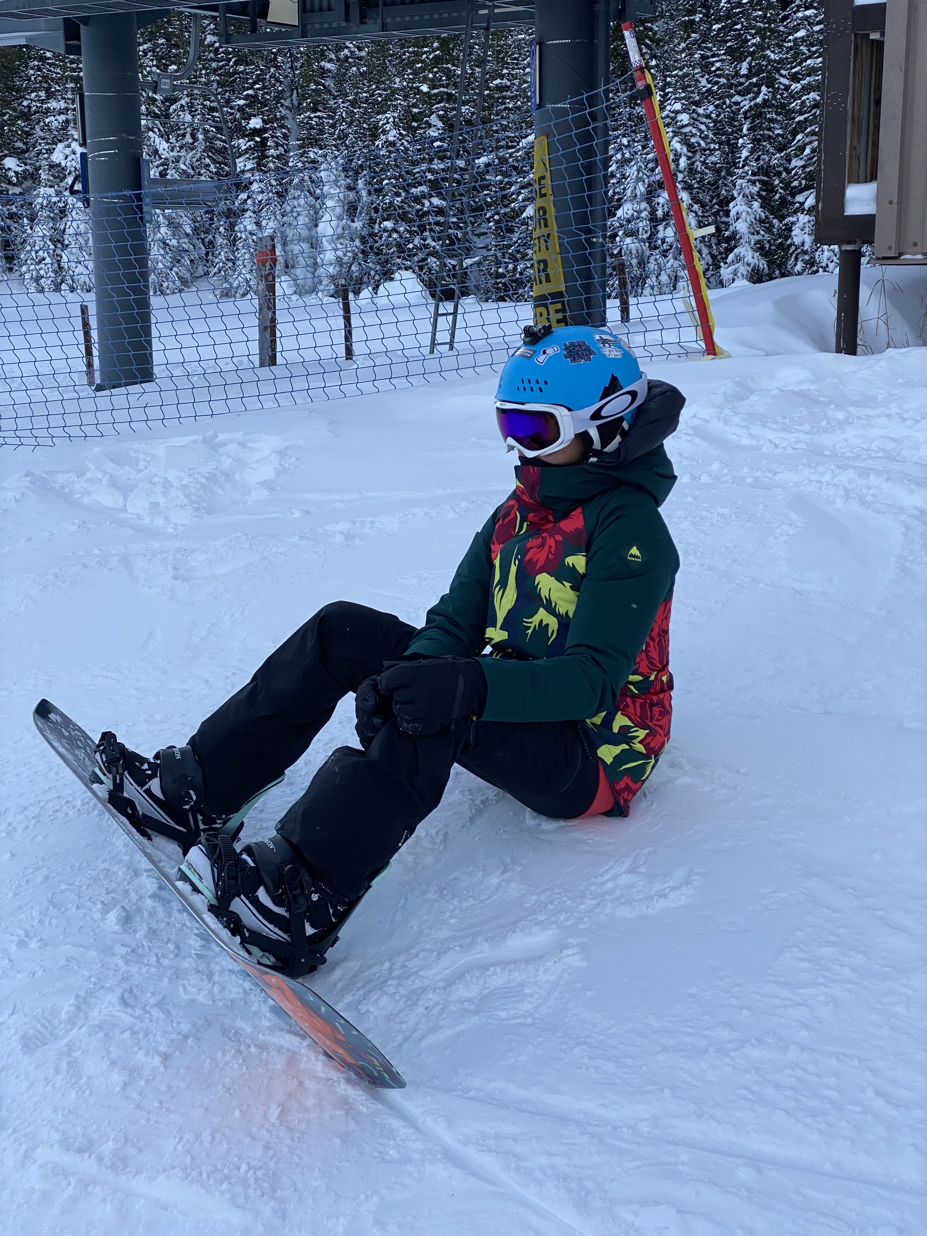 Sarah sitting on a snowboard