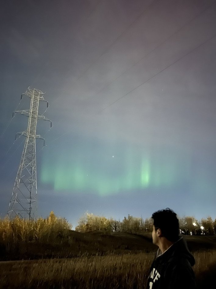 Green aurora over a power tower