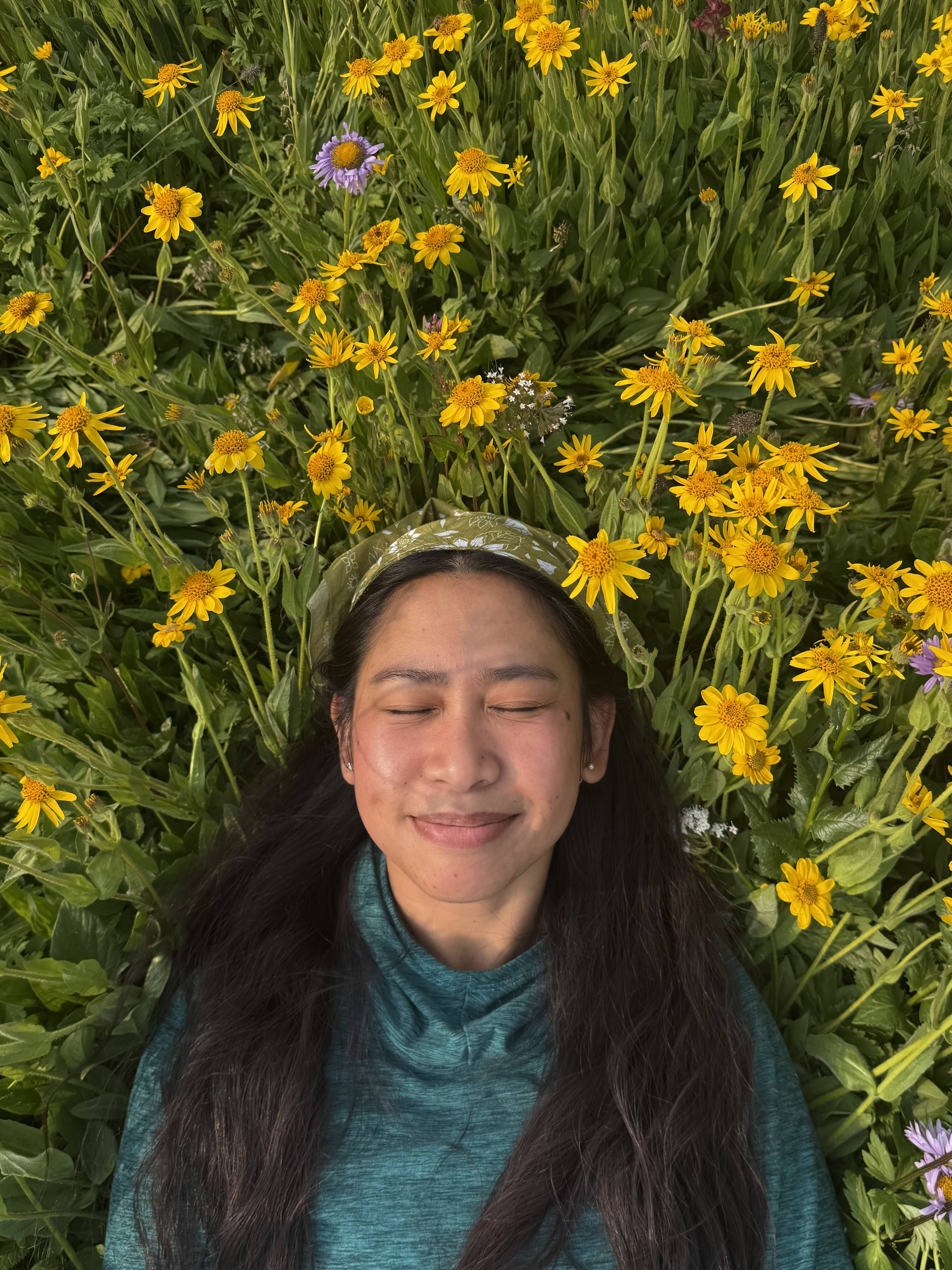 Sarah laying in a bed of yellow flowers